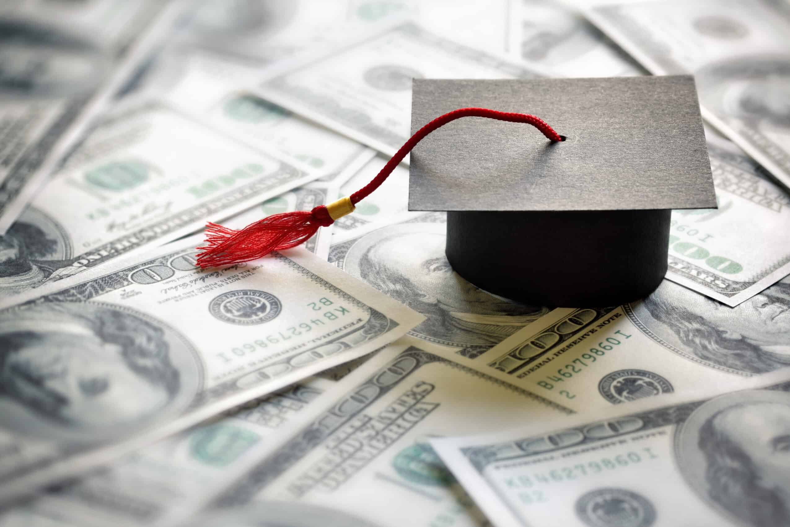 Graduation cap with dollar bills in the background