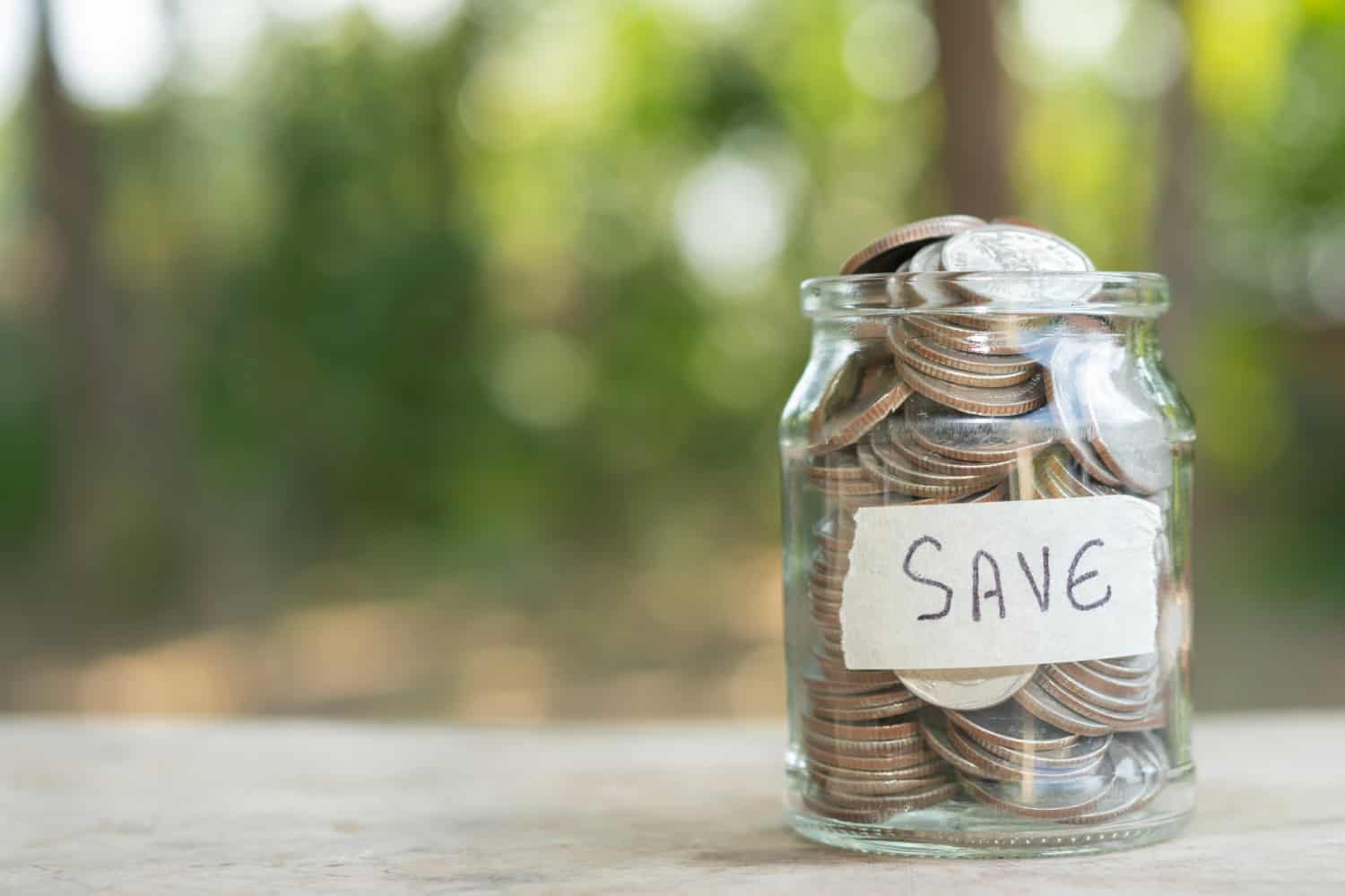 A jar of quarters with a label that says "Save"