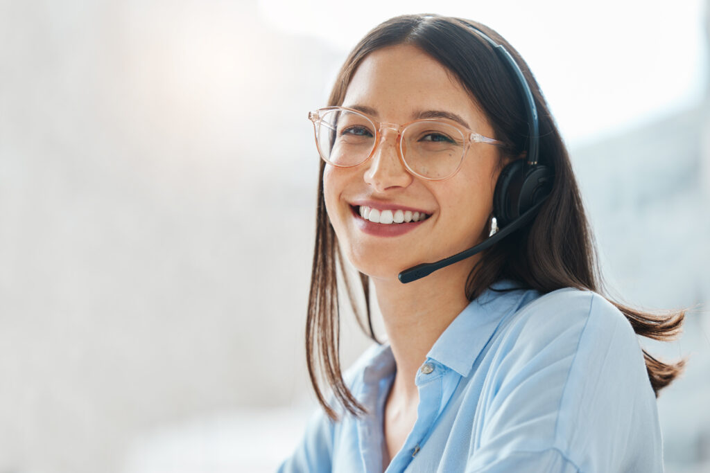 Shot of an attractive young saleswoman sitting alone in the office and wearing a headset.